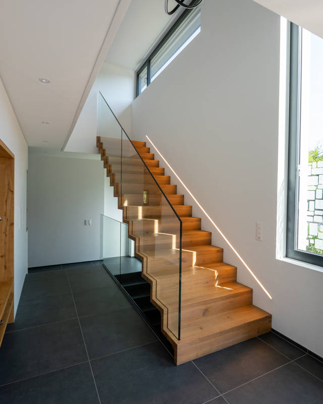 Faltwerktreppe mit Glasbrüstung und Licht.