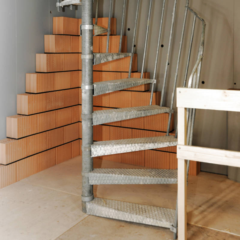 Escalier de chantier en colimaçon métallique avec balustrade rampante.