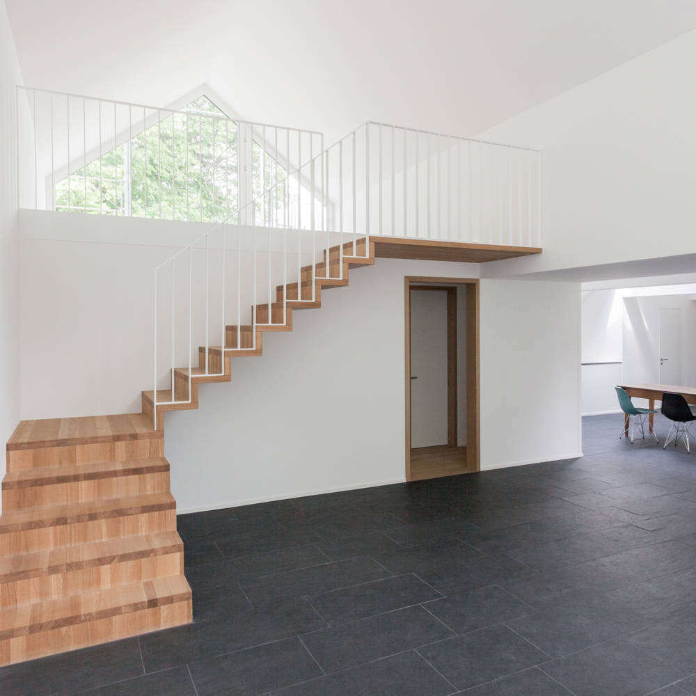 Escalier type Linea en chêne huilé natur. Balustrade en fer plat avec des barreaux verticaux, thermolaquée blanc.