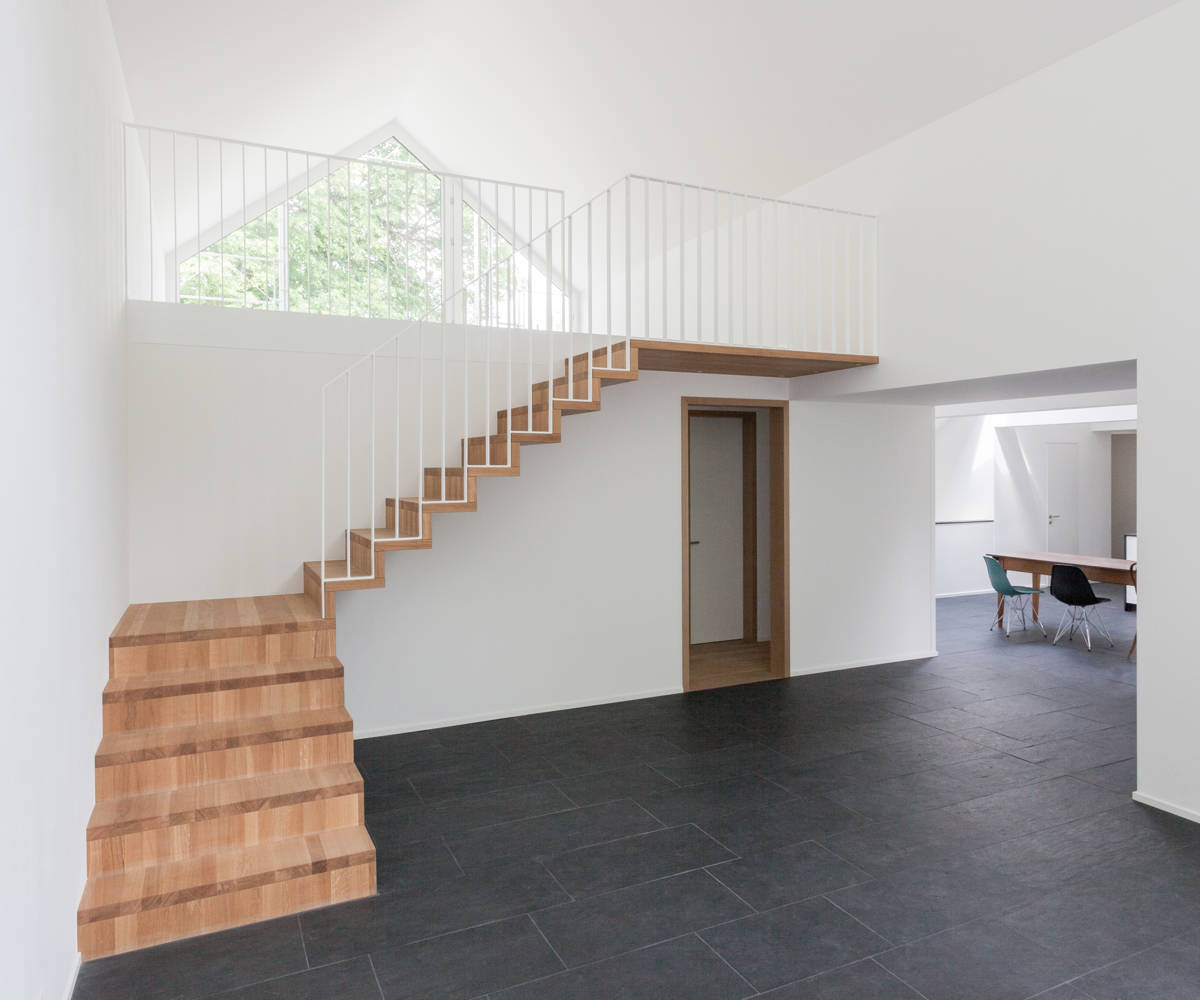 Escalier type Linea en chêne huilé natur. Balustrade en fer plat avec des barreaux verticaux, thermolaquée blanc.