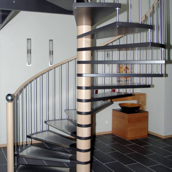 Spindeltreppe in Buche, Stufen schwarz deckend versiegelt. Stufenauflagen und Geländersprossen in Edelstahl.