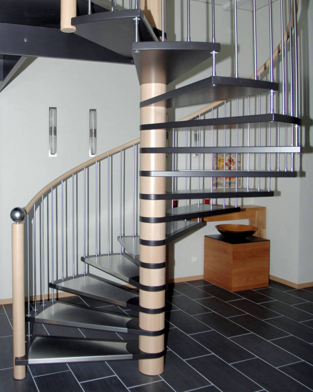 Spindeltreppe in Buche, Stufen schwarz deckend versiegelt. Stufenauflagen und Geländersprossen in Edelstahl.