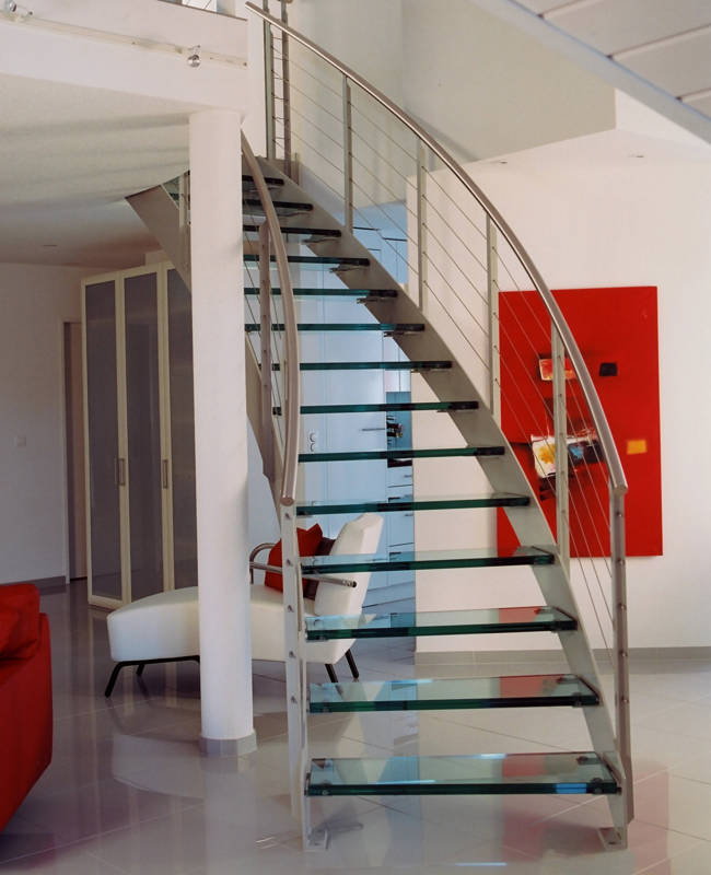 Escalier courbe, limons métals des 2 côtés, marches en verre sécurit épaisseur 31 mm, double rampes avec poteaux en fer T, câbles inox et main courante en inox.
