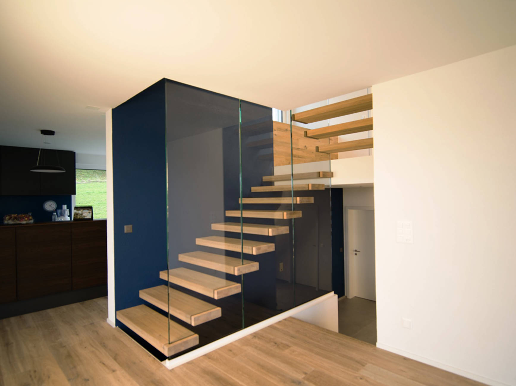 Stufen in Eiche geölt zwischen Wand und Glas.