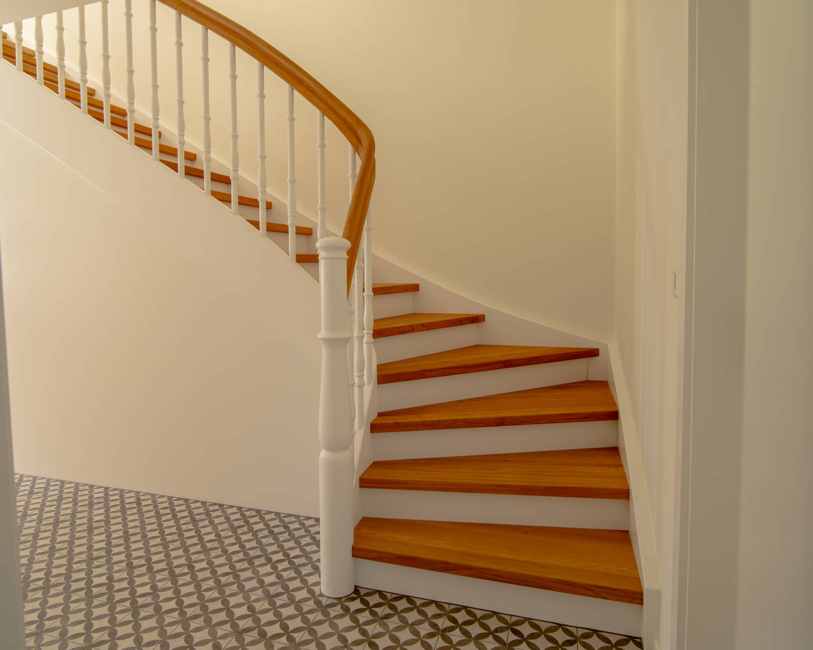Escalier en bois avec éléments laqués blancs, main-courante et marches en chêne huilé naturel.