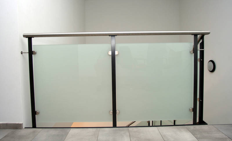 Balustrade horizontale avec poteaux en fer T, main courante inox et remplissage verre opaque.