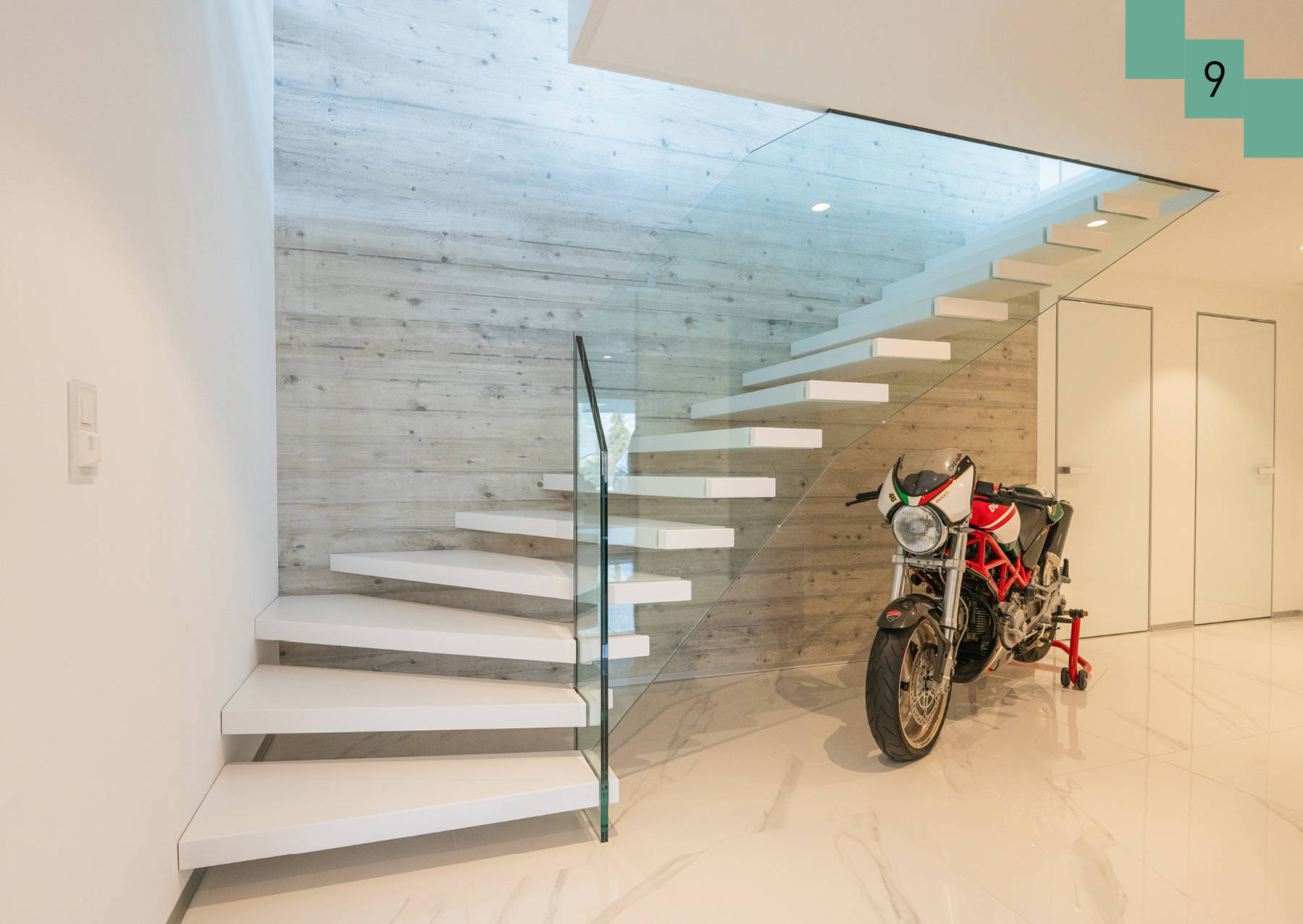 Stufen aus Wand weiss lackiert. Stufen sind durch die Glasbrüstung gestützt. 