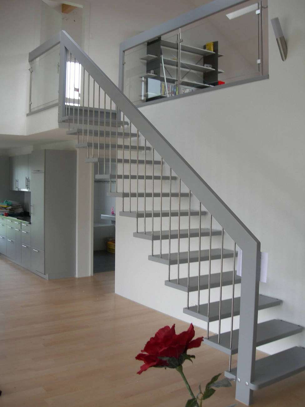 Freitragende gerade Treppe mit Edelstahlsprossen. Alle Holzteile farbig deckend versiegelt. Horizontales Rücklaufgeländer mit Verbundsicherheitsglas.