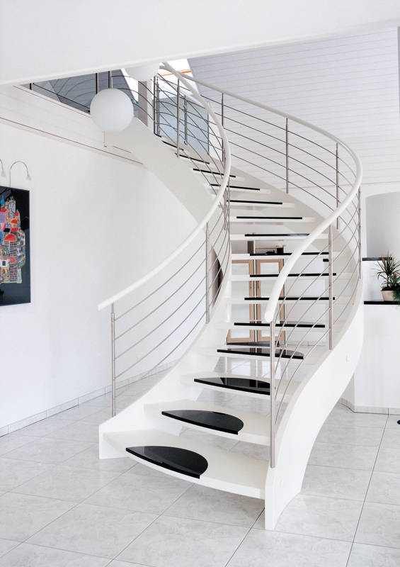 Escalier à limons cinté, bois laqué en couleur blanche. Eléments Design en Granit sur les marches, avec balustrade Reling en inos.