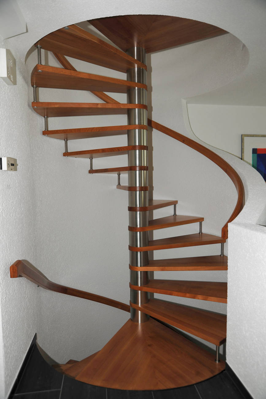 Spindeltreppe und Handlauf an Wand in europäischem Kirschbaum. Säule und Verbinder in Edelstahl.