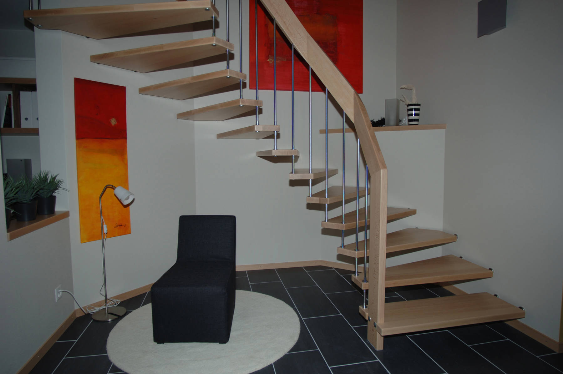 Freitragende Treppe in Buchenholz, farblos versiegelt mit Edelstahlsprossen.