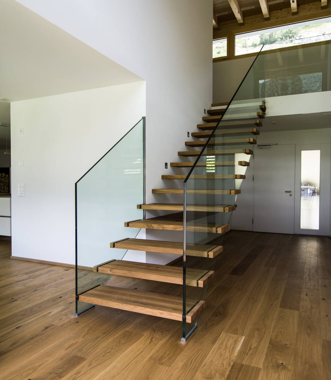 Stufen in Eiche geölt, direkt in Wand und Glasbrüstung befestigt.