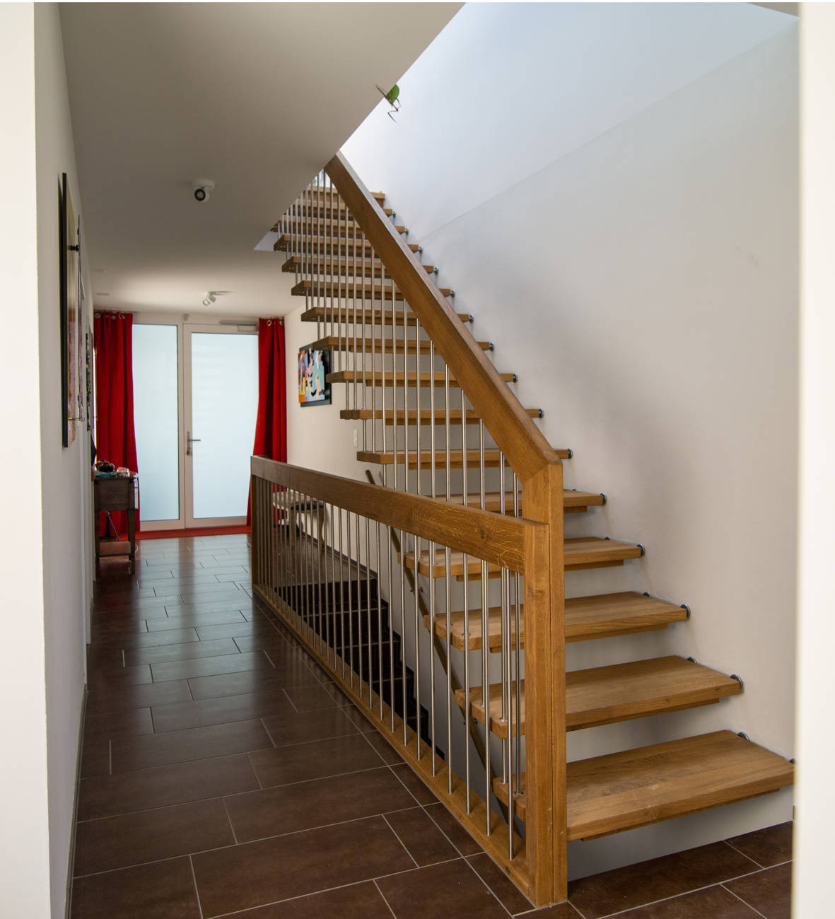 Freitragende Treppe gerade in Eiche natur geölt. Sprossen in Edelstahl. Kinderschutzleisten in Holz.