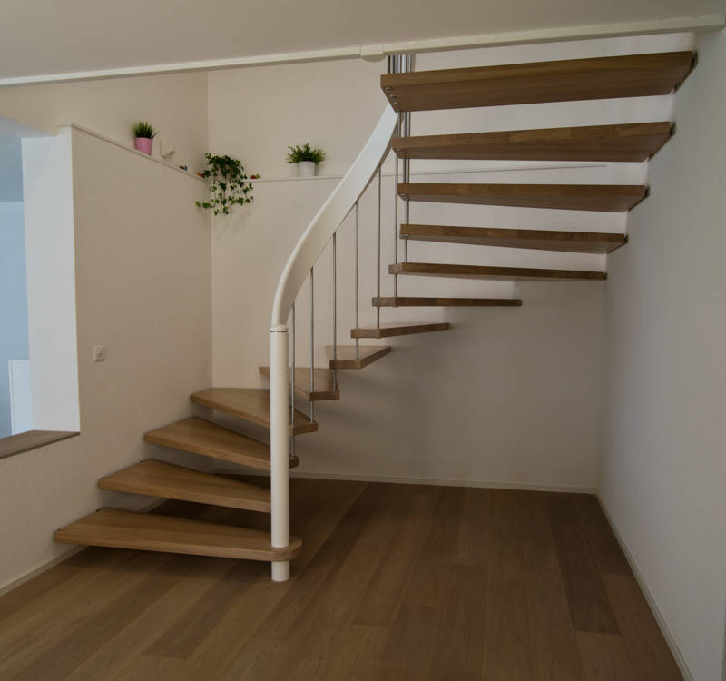 Escalier autoportant en chêne avec main courante et poteaux blanc et balustres en inox.