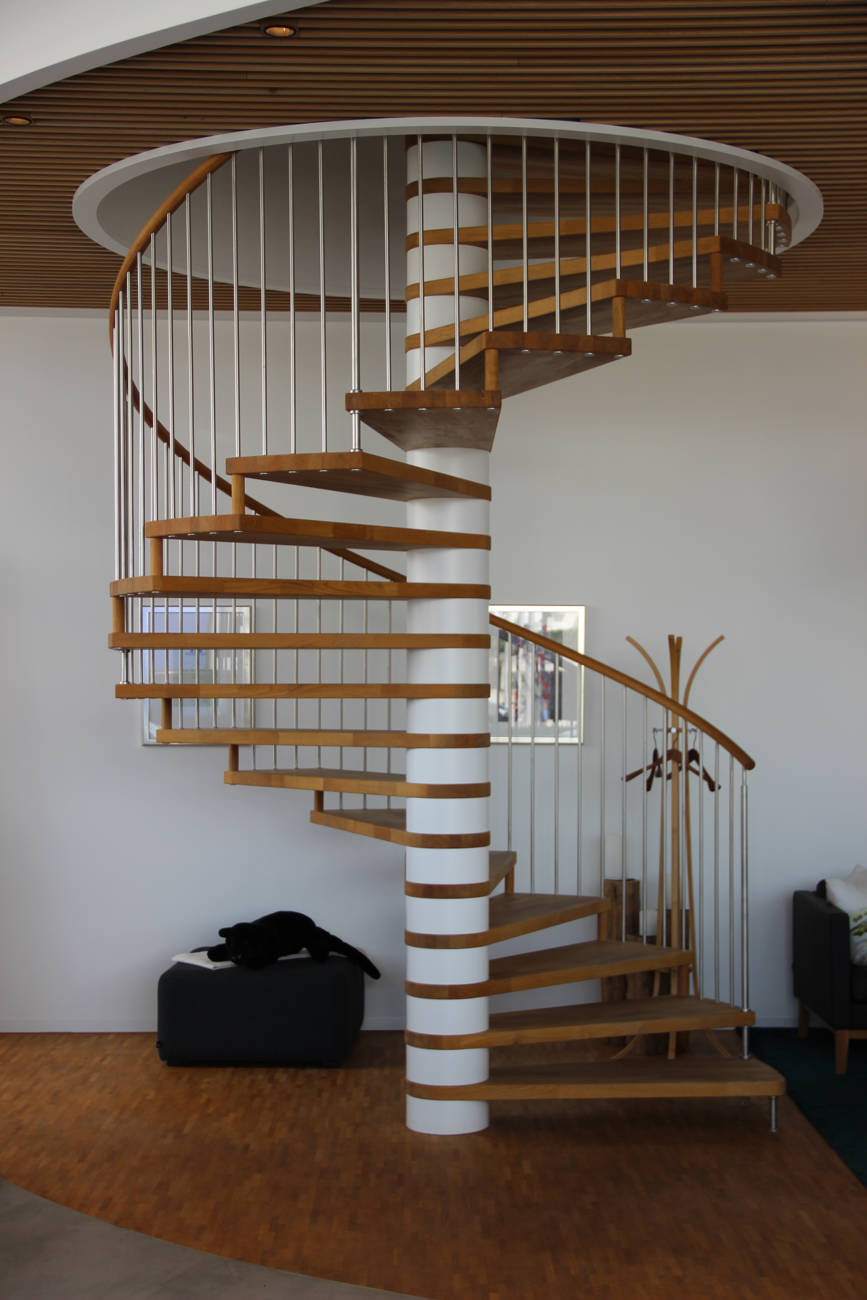 Spindeltreppe in Eiche natur geölt. Säulenteile RAL-farbig weiss deckend lackiert. Geländer mit Edelstahlsprossen und einem runden Holzhandlauf.