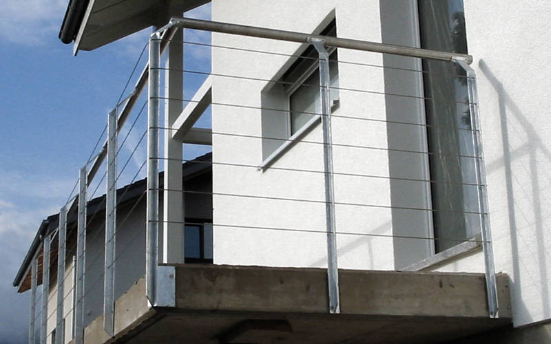 Balustrade de balcon avec poteaux en fer T en acier zingué, câbles et main courante inox.