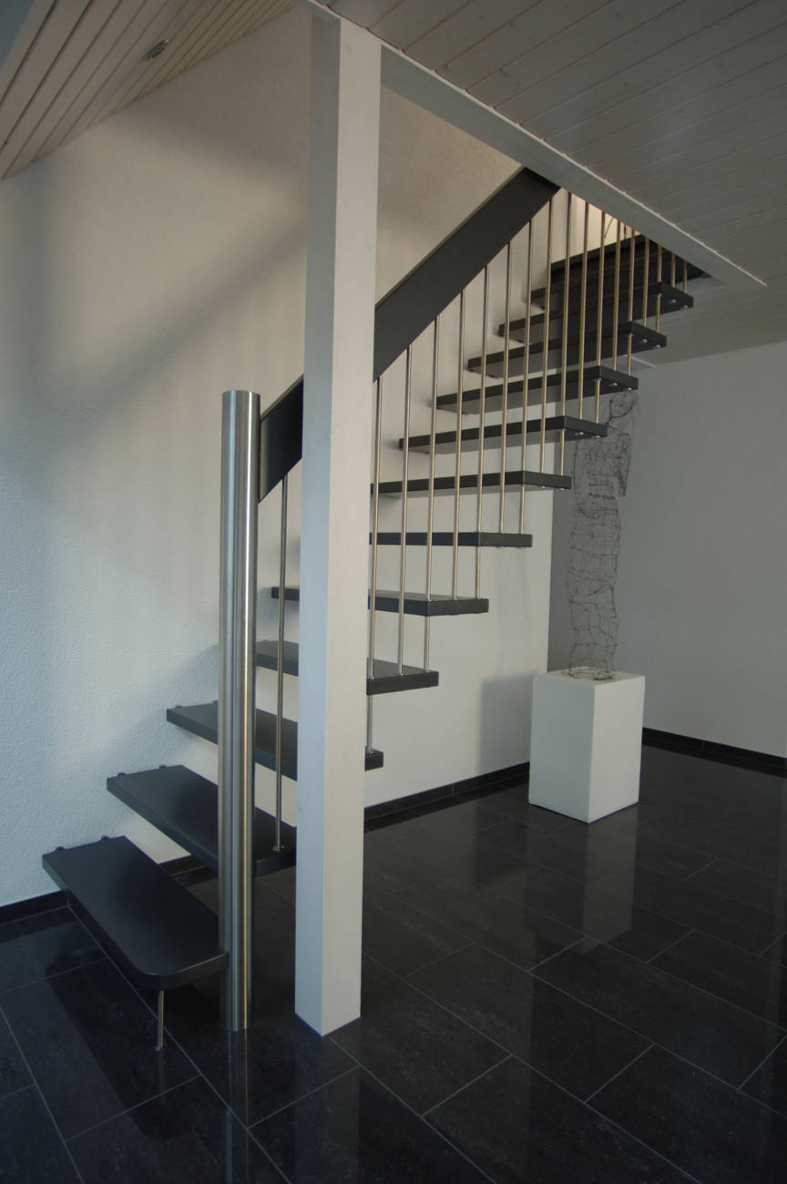 Freitragende gerade Treppe mit rundem Antrittspfosten und Sprossen in Edelstahl. Alle Holzteile farbig deckend versiegelt.