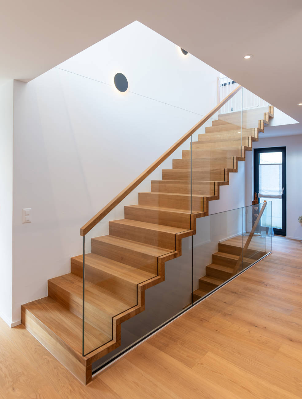 Faltwerktreppe in Eiche mit Glasbrüstung und Holzhandlauf.