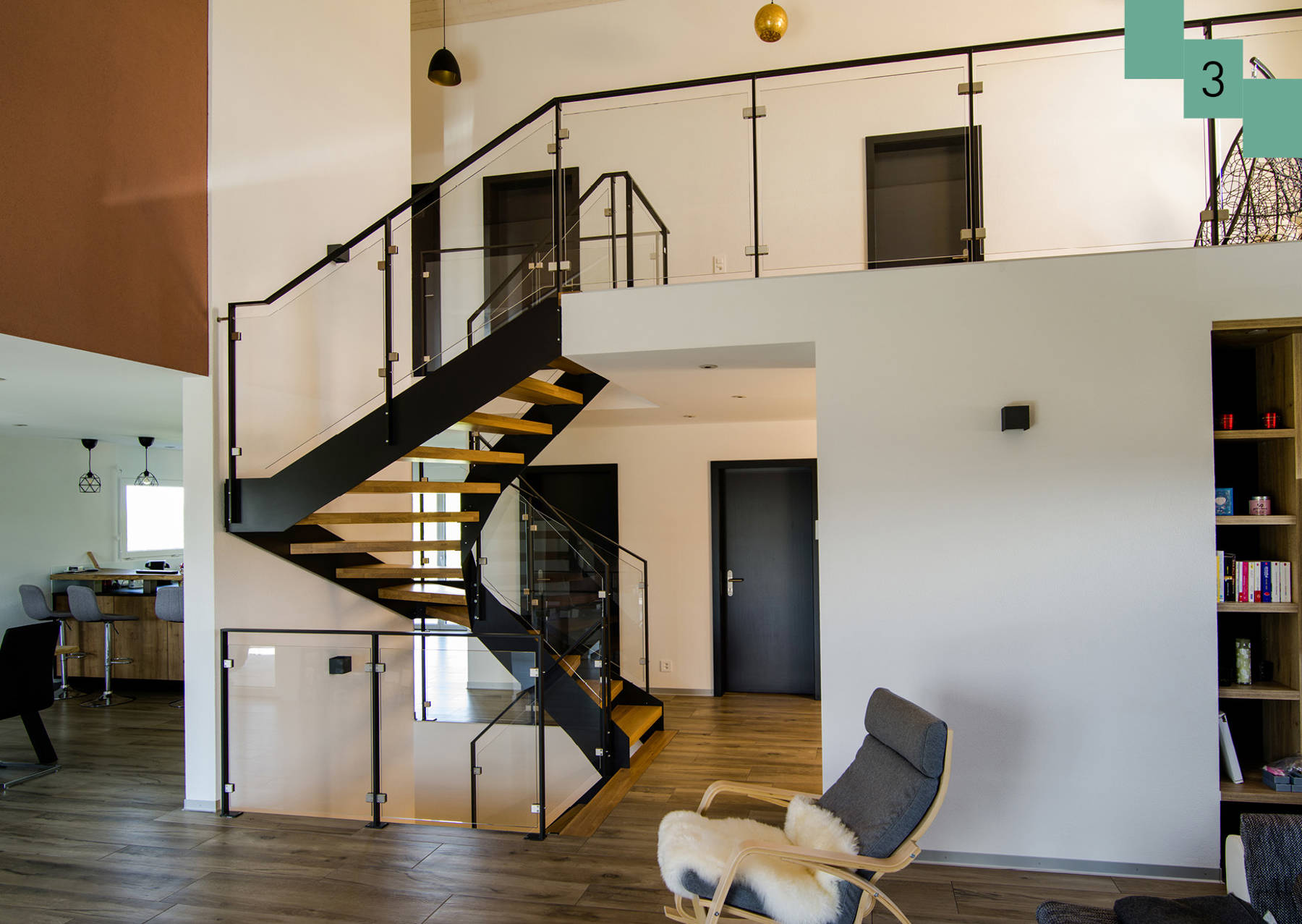 Metallwangentreppe mit Stufen in Eiche. Geländer aus Metall und mit Glasfüllungen. 