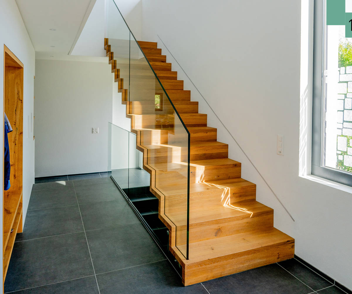 Faltwerktreppe aus Eiche mit Glasgeländer. Die Glasscheiben sind in die Stufen eigenutet. 