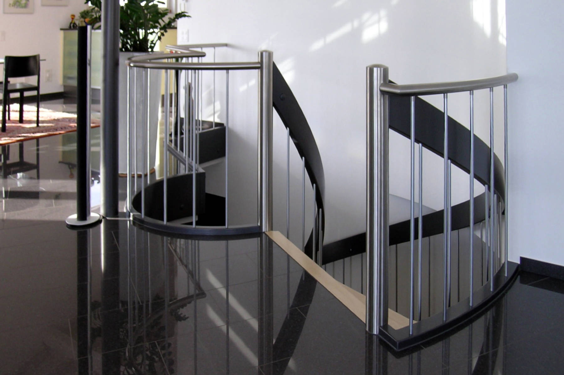 Horizontales Abschlussgeländer gebogen mit Pfosten und Sprossen in Edelstahl und einem CNS-Handlauf.