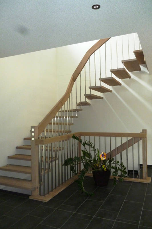 Escalier autoportant avec des balustres en inox carrés. Bois chêne huilé extrablanc.