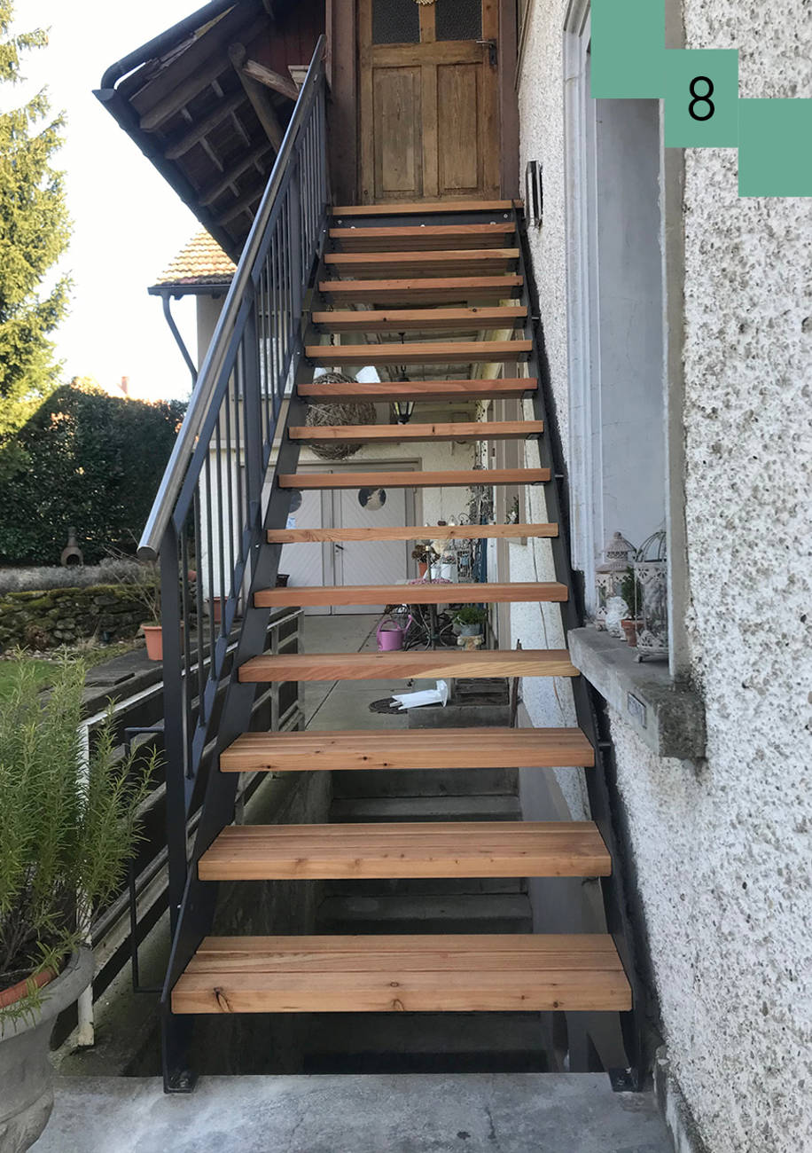 Metallwangentreppe mit Lärchenstufen. Metallgeländer mit aufgesetztem Chromstahlhandlauf. 