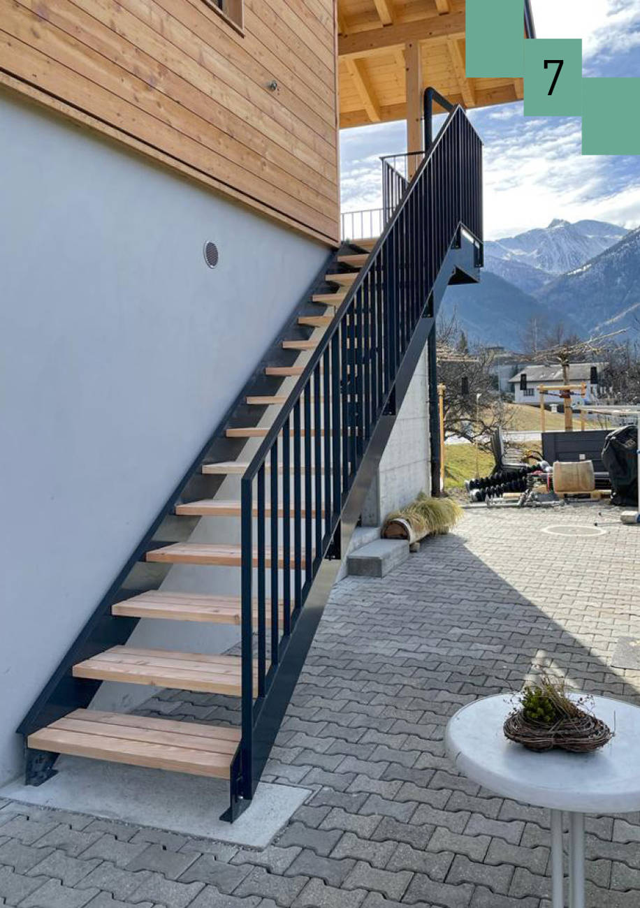 Metallwangentreppe mit Lärchenstufen und Metallgeländer. 