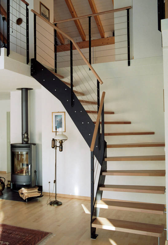 Loft-Treppe mit Innenwange aus HPL-Vollkernplatte, aussen sind die Stufen in Buche mit Spezialbolzen direkt in die Wand befestigt. Geländer mit T-Pfosten, Inox-Seilen und Holzhandlauf.