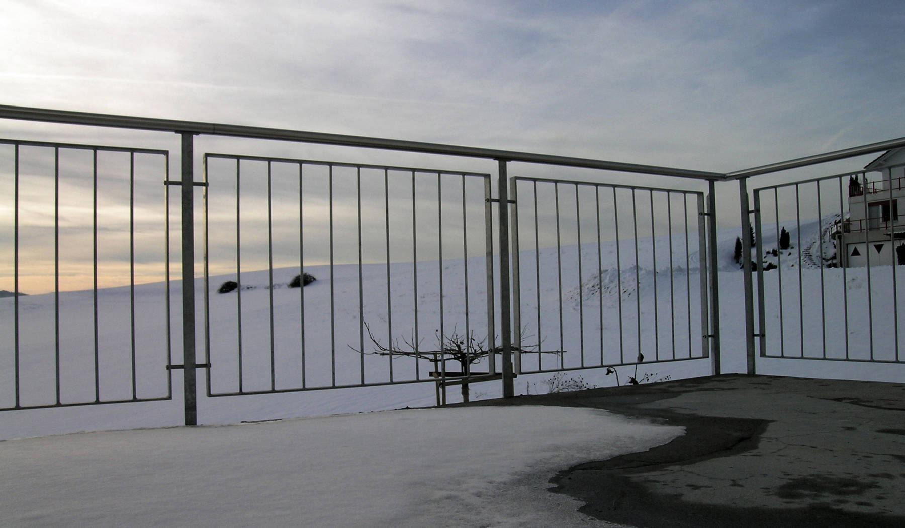 Balustrade d'extérieur avec poteaux en fer T, main courante inox. Cadre avec balustres verticaux en acier.